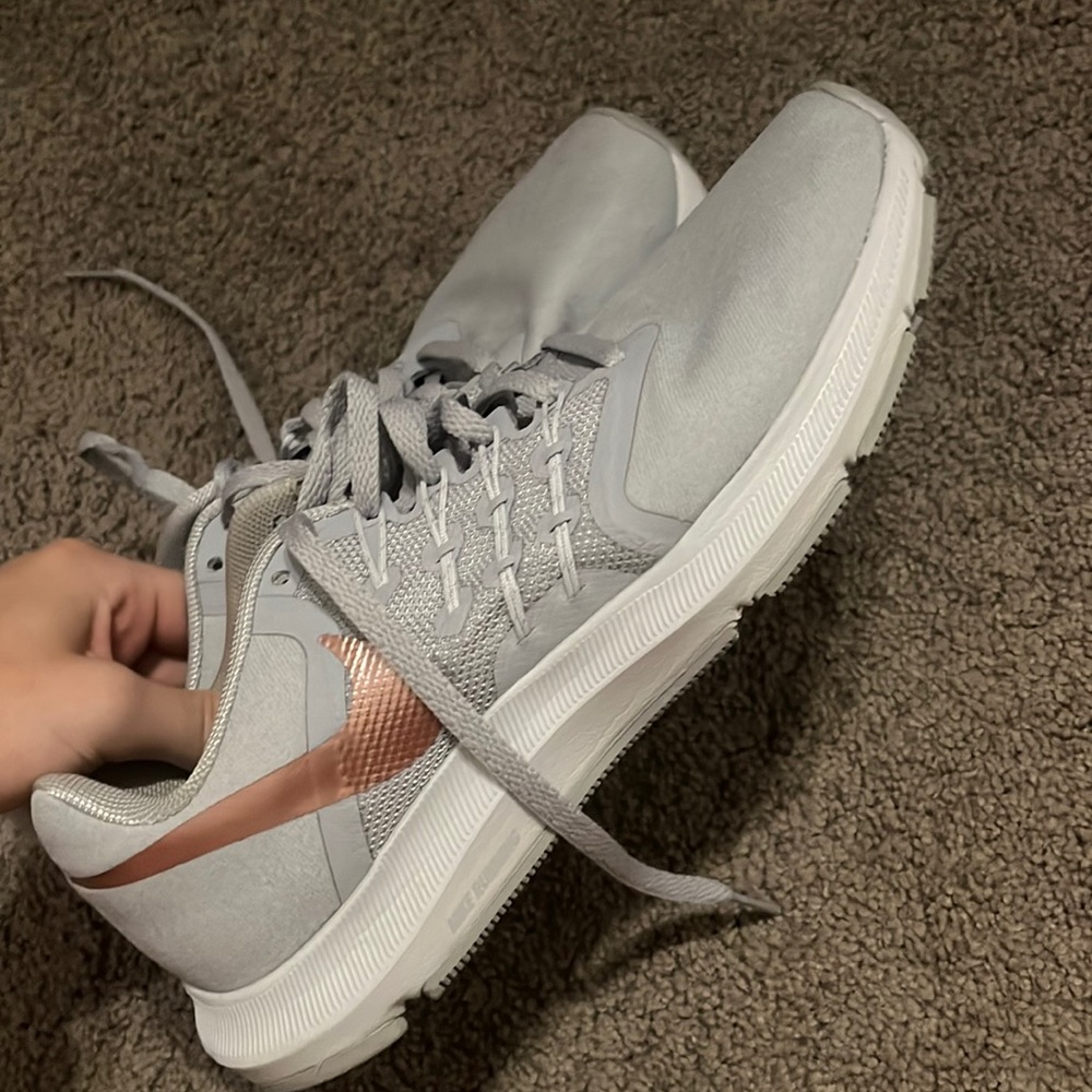 gray and rose gold nike run swift tennis shoes
